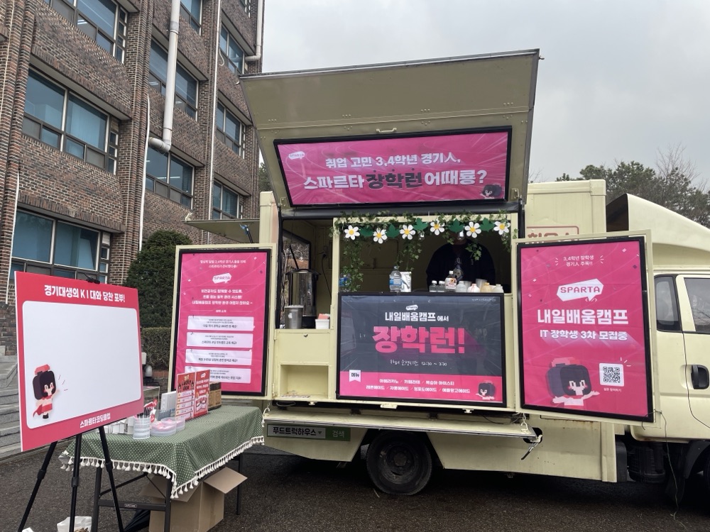 대학 캠퍼스에 선 브랜드 커피차와 줄 선 학생들